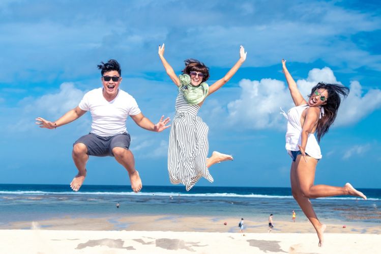 happy friends jumping beach