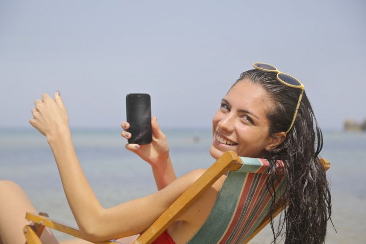 girl at beach with mobile phone